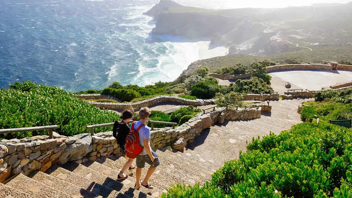 Double-decker tour bus at the Cape Point Nature Reserve gate on a penguin explorer day tour from Cape Town