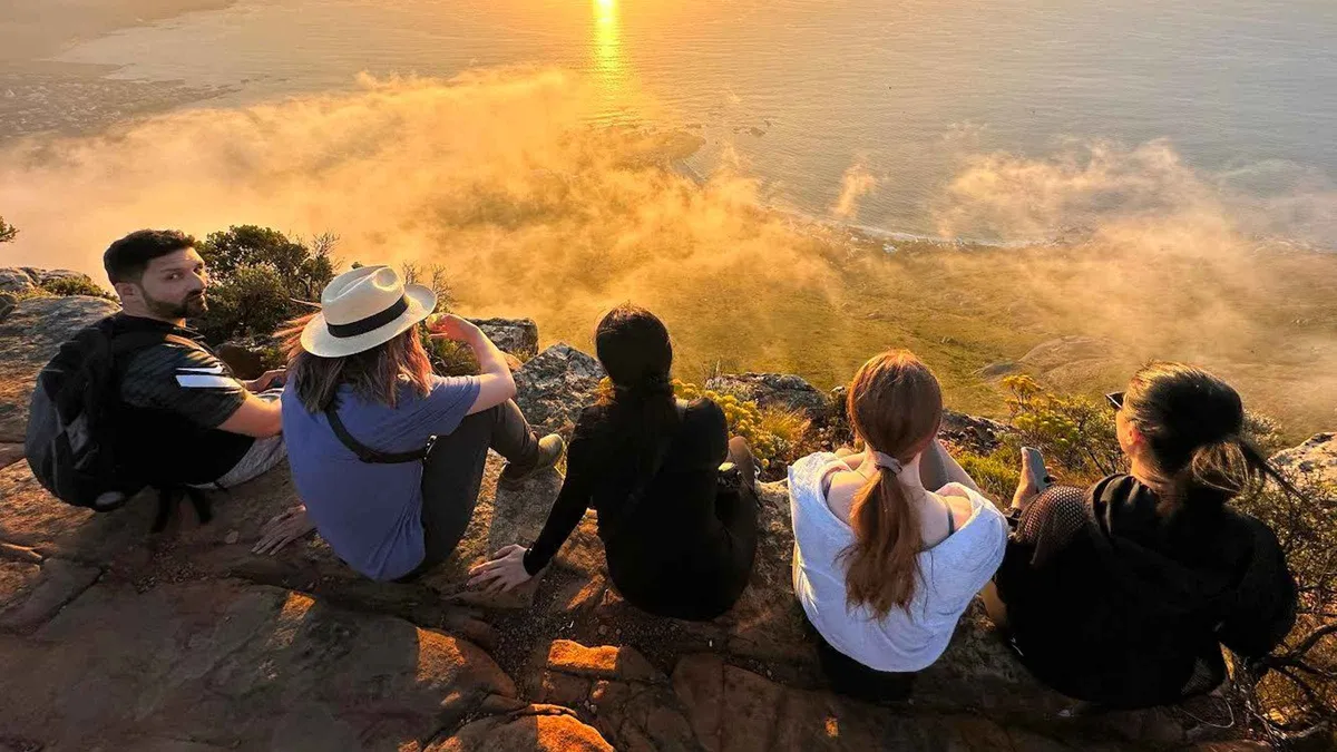 Guided group scrambling up the Lion's Head trail at sunrise on a Cape Town hike