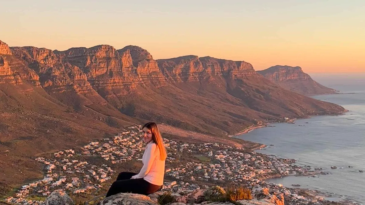 Sunrise breaking over Table Bay seen from the Lion's Head summit on a guided hike, Cape Town