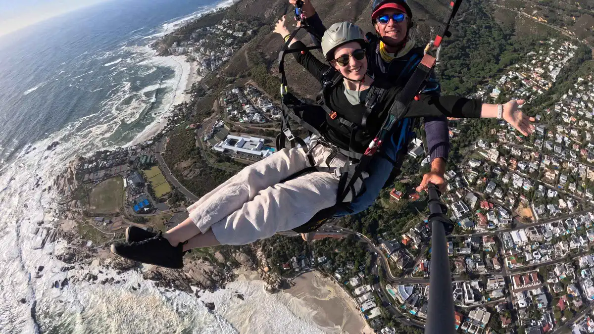Tandem paraglider launching from Signal Hill above the Atlantic seaboard, Cape Town