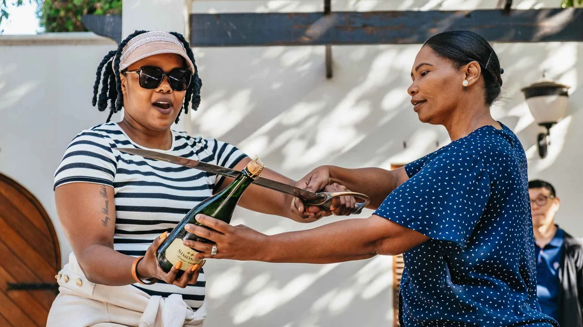 Cellar tour among oak barrels on a three-region winelands tour from Cape Town